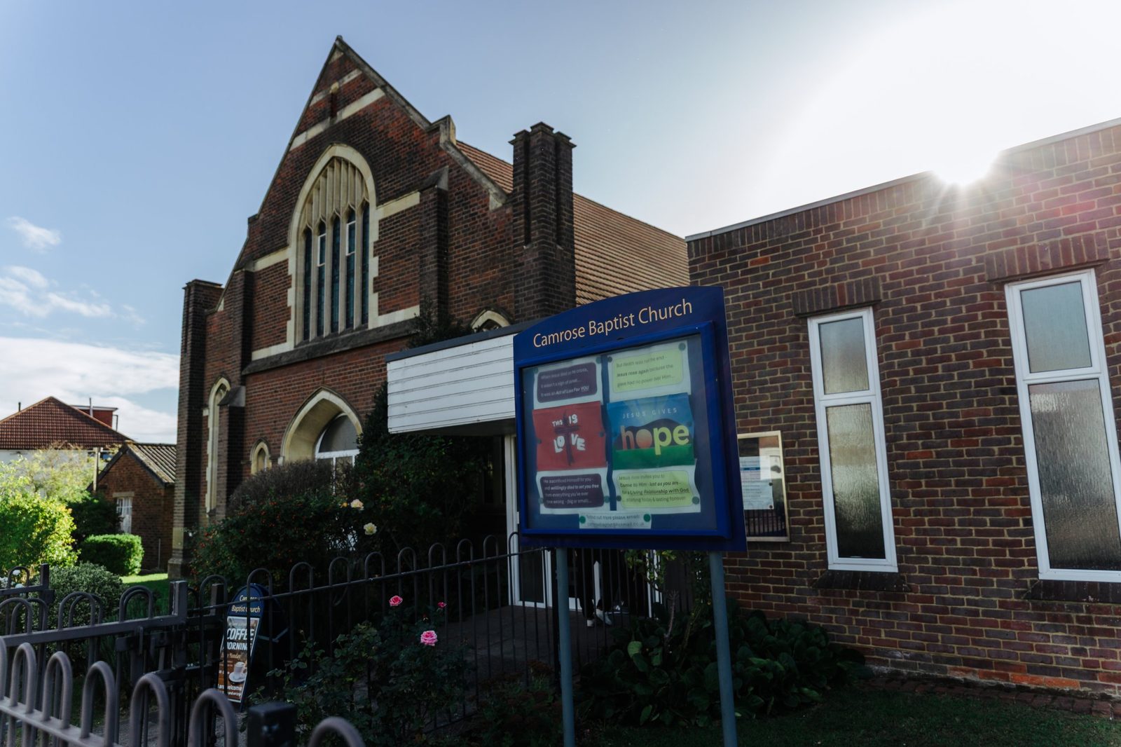The front of Camrose Baptist Church, with the church noticeboard in the foreground